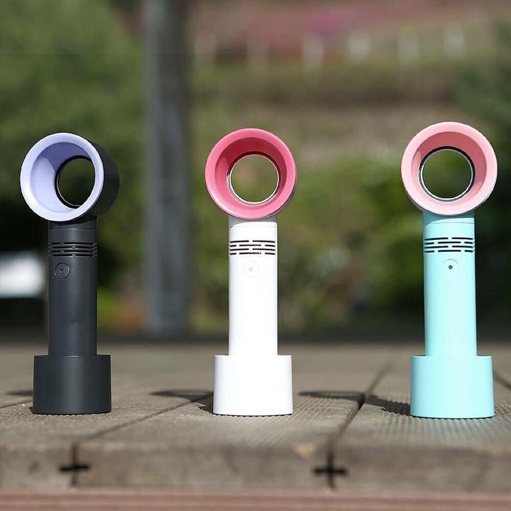 Three colorful portable bladeless fans in black, white, and blue on a wooden surface outdoors